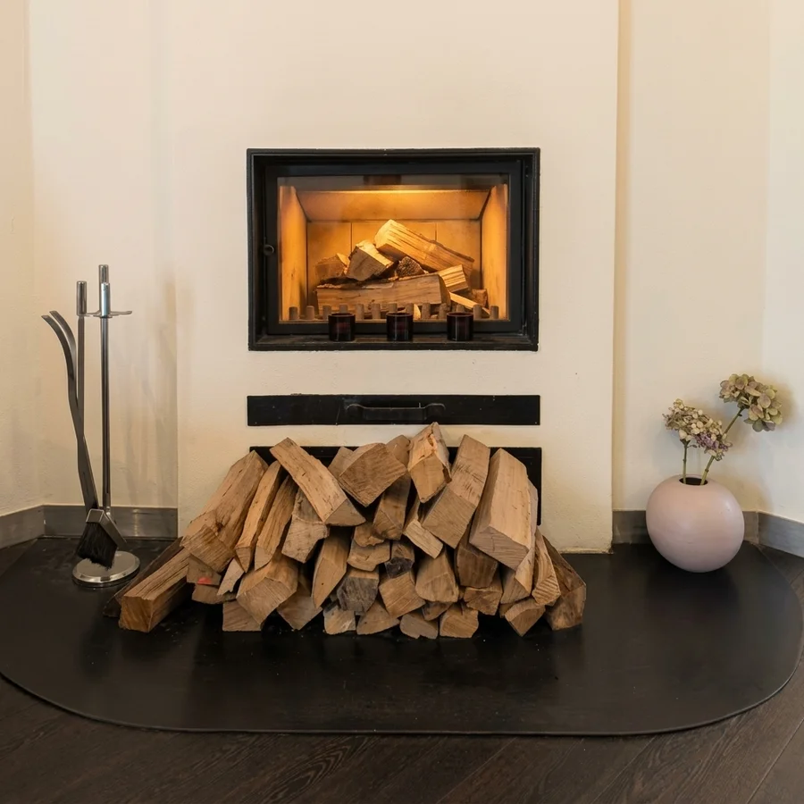 Kamin im Salon mit Holzfeuer und Hortensien
